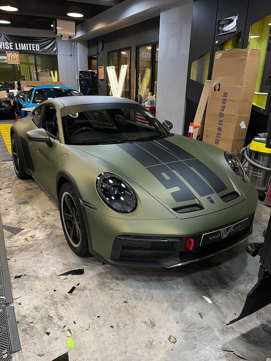 Porsche 992 Dakar wrapped in Inozetek Dynamic PPF, featuring Frozen Metallic Titanium Green, Satin Blackout, Dry Carbon Fiber, and Gloss Italia Red.
