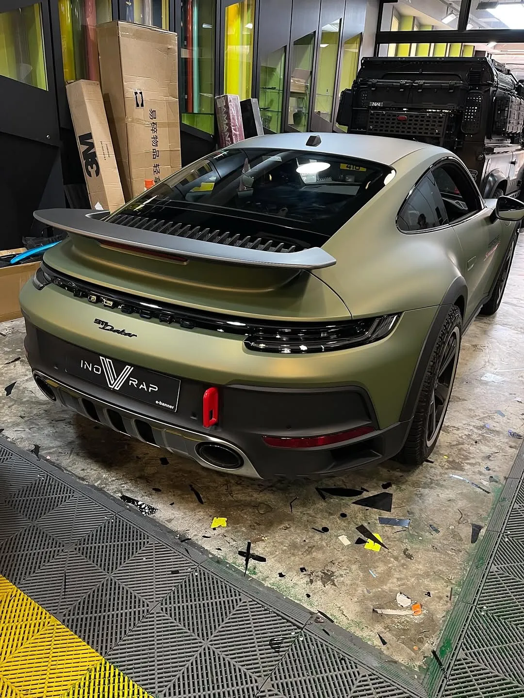 Porsche 992 Dakar wrapped in Inozetek Dynamic PPF, featuring Frozen Metallic Titanium Green, Satin Blackout, Dry Carbon Fiber, and Gloss Italia Red. View 1