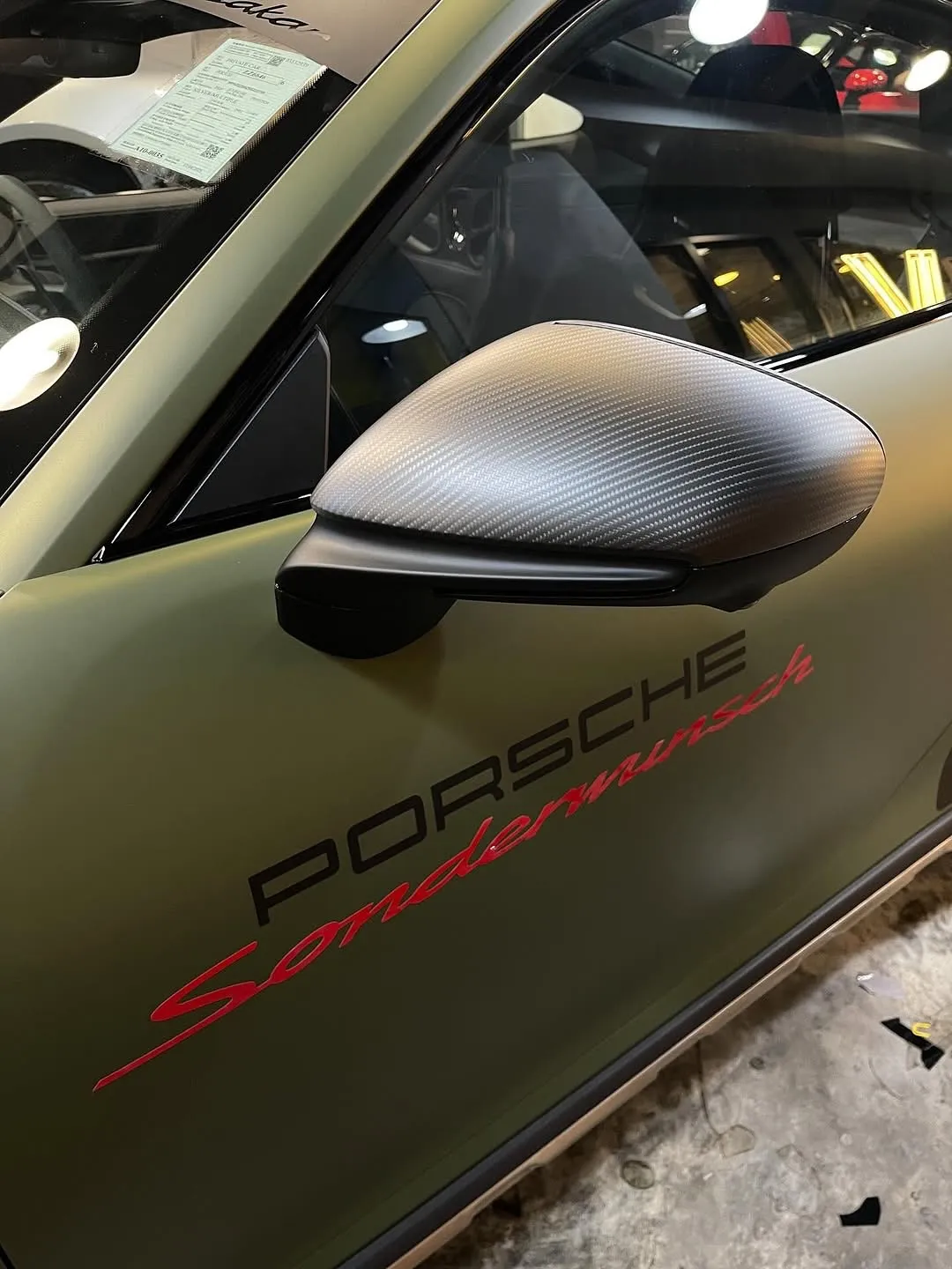 Porsche 992 Dakar wrapped in Inozetek Dynamic PPF, featuring Frozen Metallic Titanium Green, Satin Blackout, Dry Carbon Fiber, and Gloss Italia Red. View 2